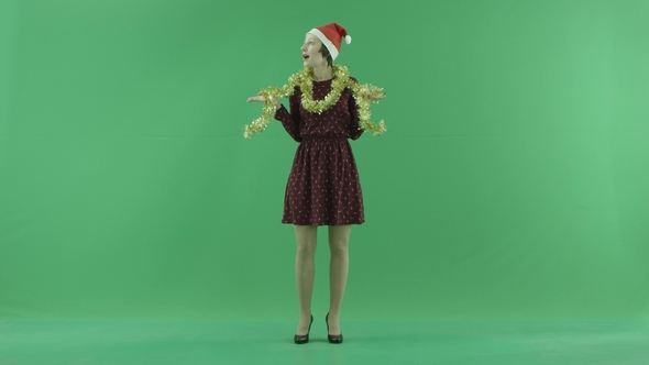 A Young Christmas Woman Is Looking Around on the Green Screen