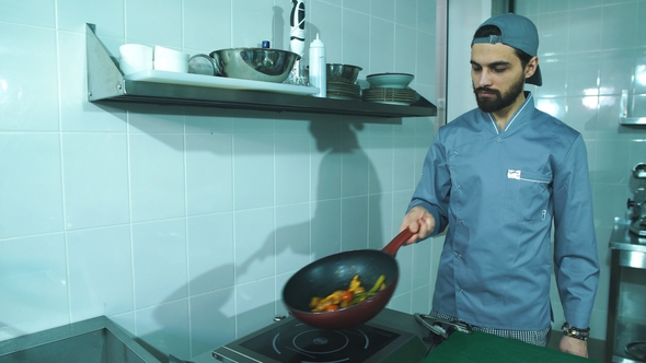 Frying Pan with Vegetables in Chef Hand. Male Chef Cooking Vegetables at Restaurant