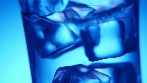 Five Ice Cubes Are Shaken in a Clear Glass in the Blue Background