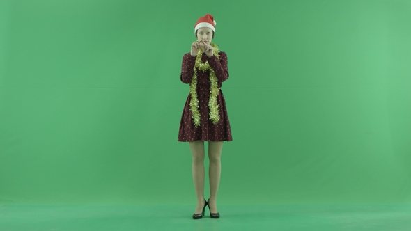 A Young Christmas Woman Is Showing Love To the Viewer on the Green Screen alt