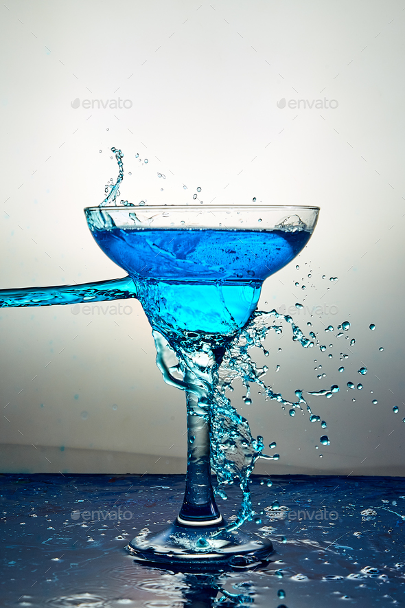 Glass with blue champagne or cocktail. Levitation Stock Photo by bondarillia