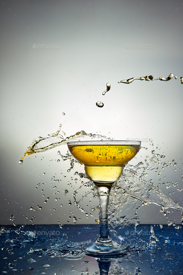Glass with yellow champagne or cocktail. Levitation Stock Photo by bondarillia