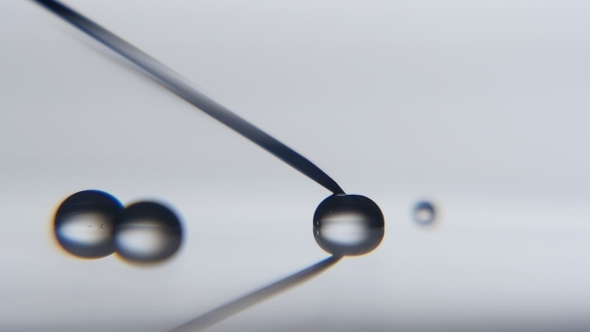 Crystaline Water Drop Gets Big Touching a Metallic Needle in a Scientific Lab