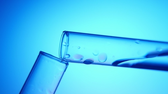 Clean Fluid Is Poured From One Tube Into Another in a Medical Laboratory