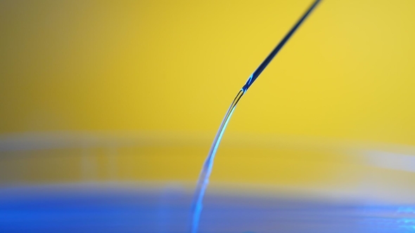 Tiny Transparent Drops Come Down From a Metallic Needle on Glass in a Lab