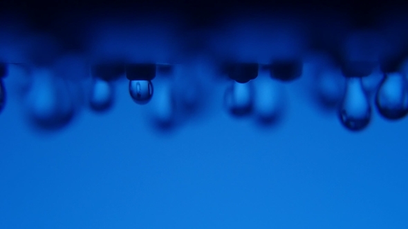 Hazzy Water Blobs Come Down From a Shower Nozzle in a Blue Background