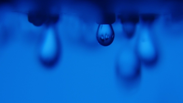 Vague Water Blobs Fall From a Shower Nozzle in a Blue Background