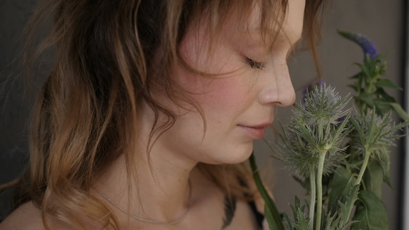 Woman Is Smelling the Flowers