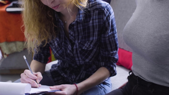 A Young Woman Shows His Sketches and Ideas To a Friend in the Atelier