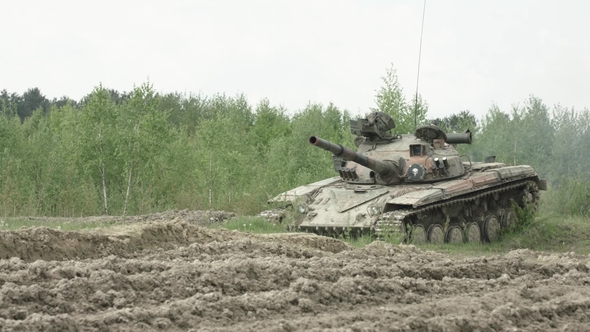 Military Tank in Movement on a Dirt Ground Terrain alt