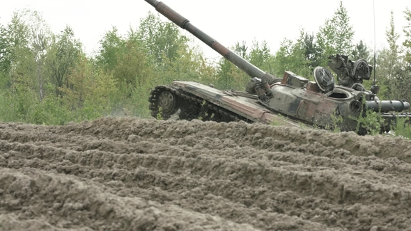 Military Tank in Movement on a Dirt Ground Terrain alt