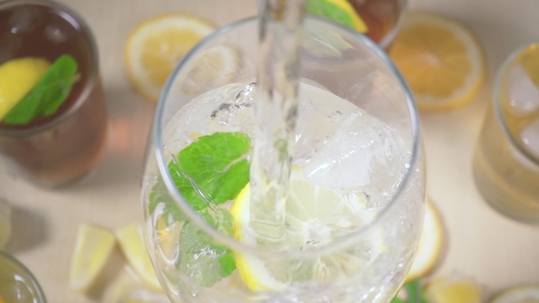 Water Is Poured Into a Glass of Ice and Mint