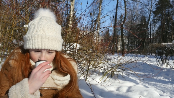 Ginger-Haired Teenage Girl Walking and Drinking a Hot Tea on Winter Park