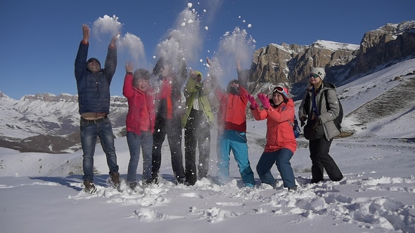 Group of Tourists Throws Snow on a Mountain Pass