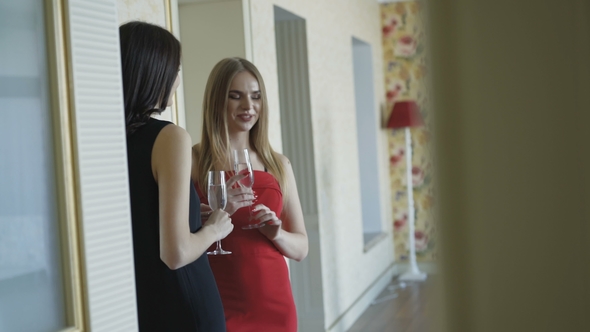 Three Pretty Girls in Dresses Having a Small Talk and Drinks Champagne alt