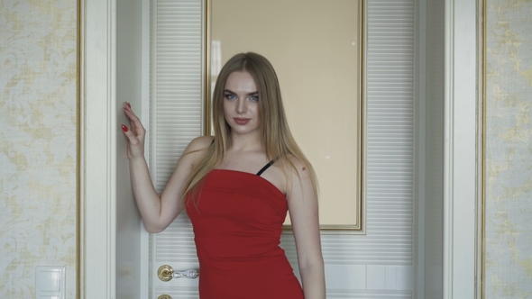 Seductive Blue-eyed Blonde in Red Dress Posing at Camera alt