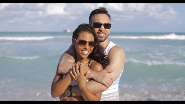 Embracing Diverse Couple on Shoreline alt