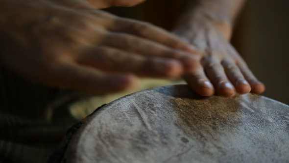 Man's Hands Drumming Out a Beat on an African Skin-covered Hand Drum.