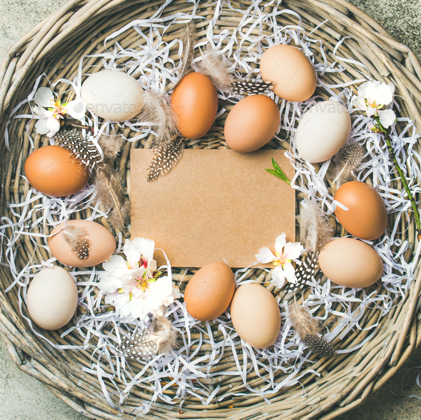 Natural colored eggs for Easter in basket over grey background - Stock Photo - Images