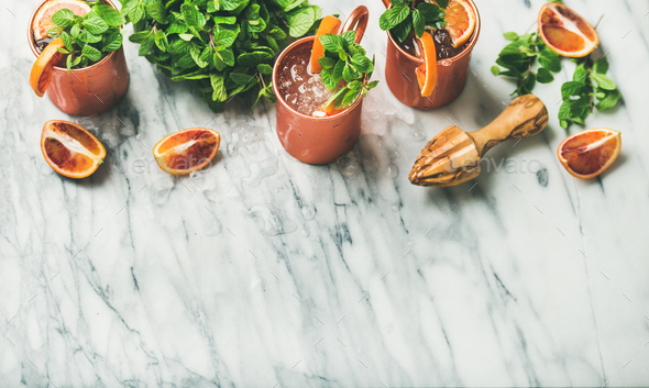 Blood orange Moscow mule alcohol cocktails over marble background - Stock Photo - Images