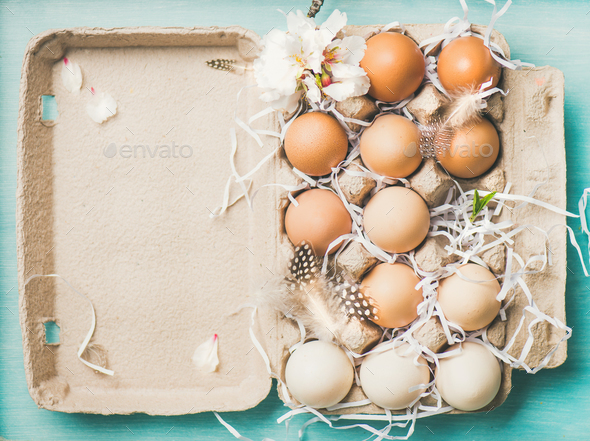 Natural colored eggs for Easter in box, blue background - Stock Photo - Images