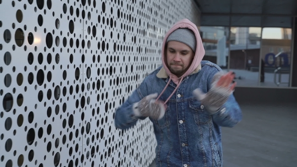 Man Is Dancing Next To Perforated Wall