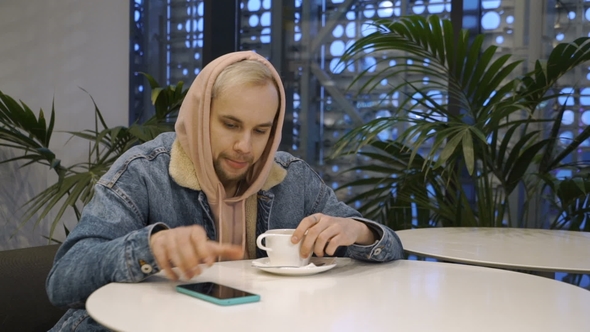 Man Is Going To Dial Sitting in Cafe alt