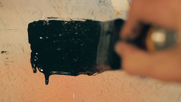 Artist Draws With a Brush on Colorful Wall With Black Paint. Paint Flows Down.