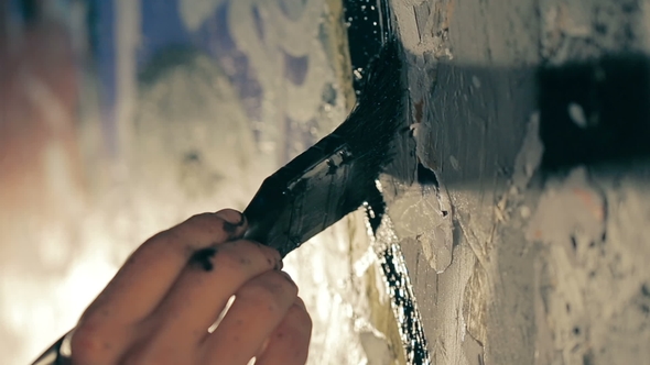 The Painter Paints the Wall in Black Color.
