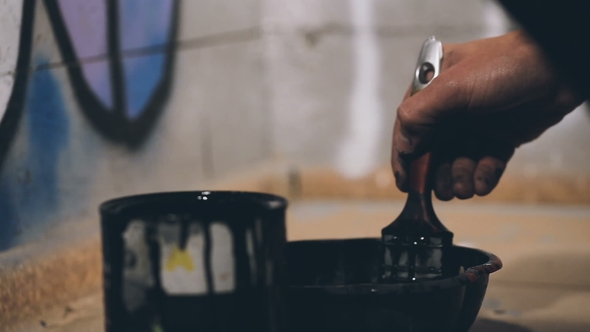 Man Is Mixing a Black Paint in a Bowl.