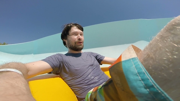 Young Man Sliding Down at the Aquapark alt