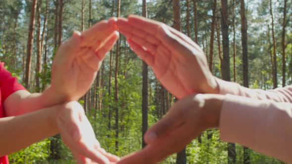 Couple Showing Shape of Earth with Hands Outdoors alt