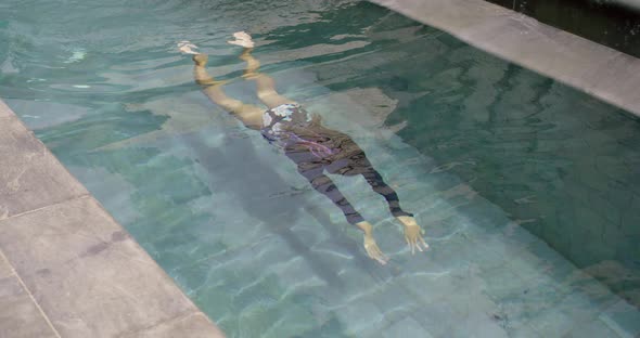 Young Girl Swimming Under the Water in the Swimming Pool at Luxury Villa alt