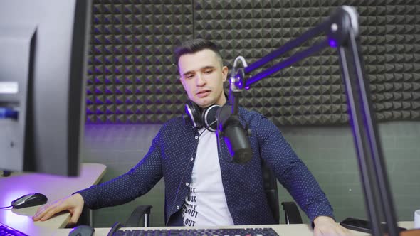 a Male Radio Host Conducts a Live Broadcast in a Professional Radio Studio alt