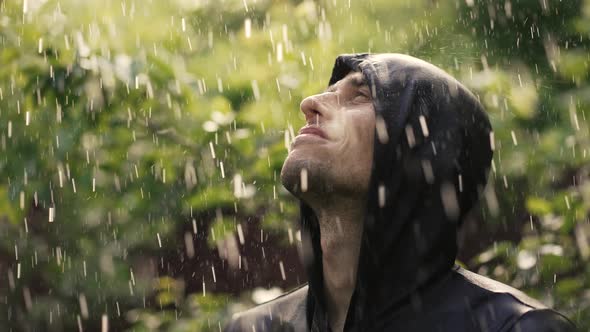 Happy Young Man Under Rain Looking Up alt