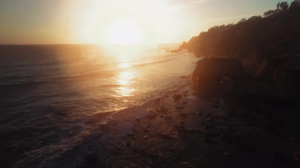 Aerial shot of huge rock on sandy dusky oceanside at El Matador Beach, Malibu, Califronia, USA alt