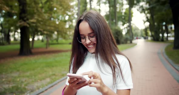 Woman Walking and Scrolling Smartphone