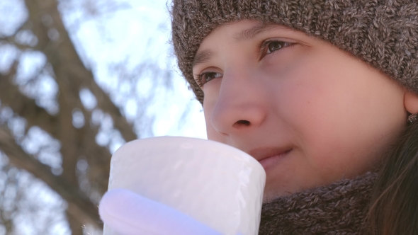 Hild Froze and Drinks Hot Tea From Hot Mug and Smiles alt
