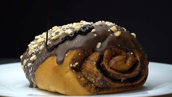 A Chocolate Roll Is Pouring By Hot Melted Cocoa. alt