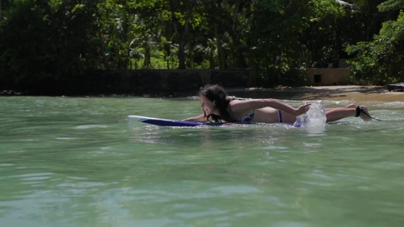 The Girl is Floating on a Surfboard