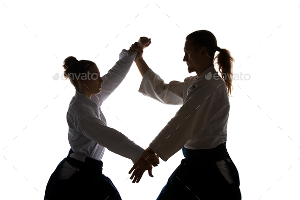 Man and woman fighting at Aikido training in martial arts school - Stock Photo - Images