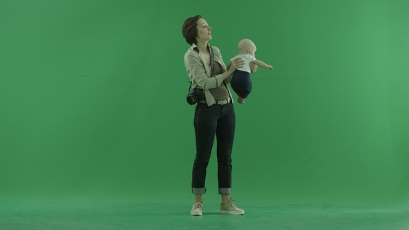 A Young Woman Lift Her Child on the Green Screen