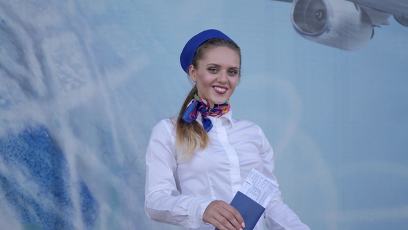 Stewardess Holds in Hand Passport with Tickets and Shows Symbol of Approval Like on Camera alt