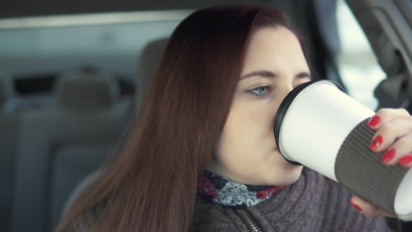 Woman Drinks Coffee in Car