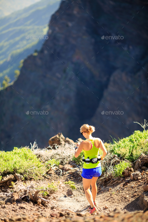 Woman walking running in rocky mountains on summer day - Stock Photo - Images