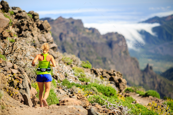 Young woman running or hiking in mountains - Stock Photo - Images