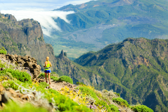 Woman running in mountains on sunny summer day Stock Photo by blas