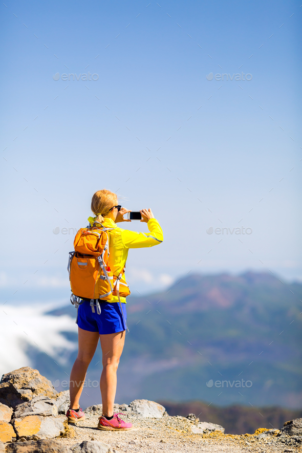 Woman hiker taking photos in mountains - Stock Photo - Images