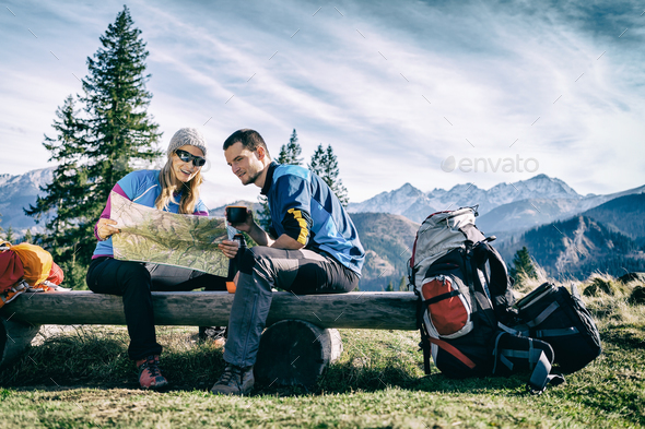 Couple hikers with map in mountains - Stock Photo - Images