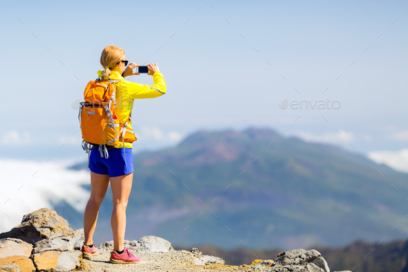 Woman hiker taking photos in mountains - Stock Photo - Images